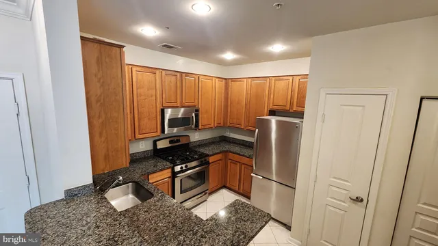 a kitchen with stainless steel appliances granite countertop a refrigerator and a sink
