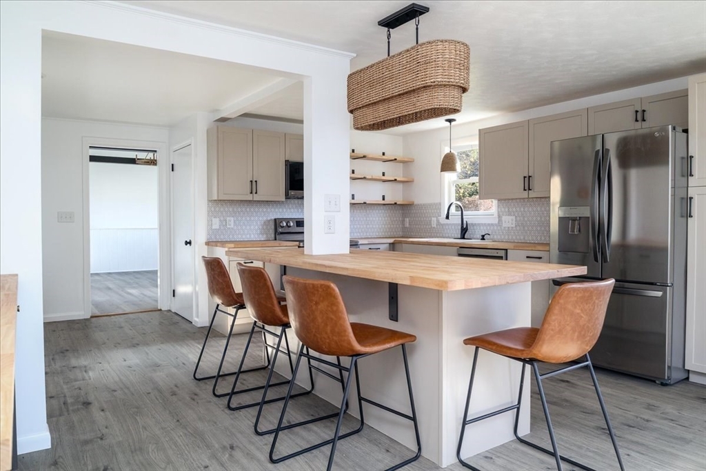 18 Claffey Avenue Worcester, MA 01606 - Photo 2 of 39 a kitchen with stainless steel appliances granite countertop a dining table chairs refrigerator and sink