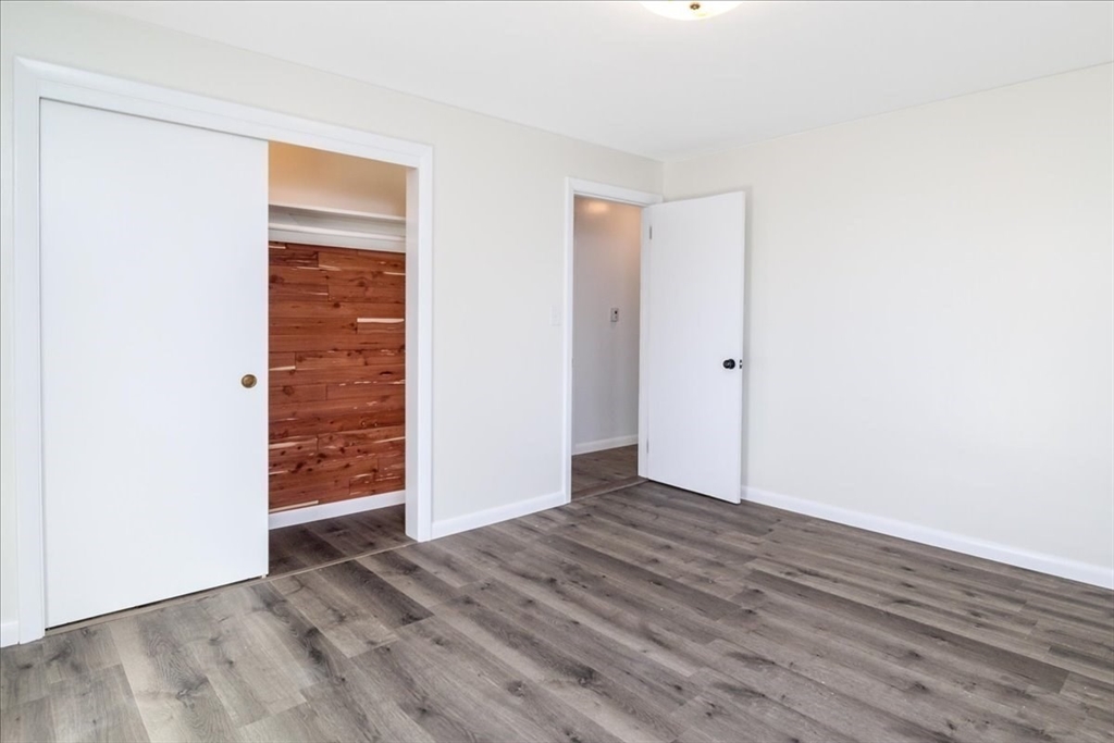 18 Claffey Avenue Worcester, MA 01606 - Photo 29 of 39 an empty room with wooden floor & windows
