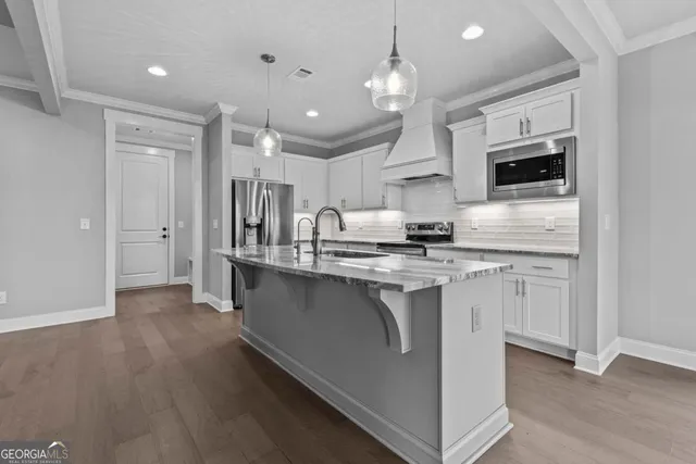 a kitchen with stainless steel appliances granite countertop a stove and cabinets