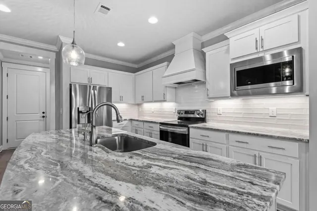 a kitchen with stainless steel appliances granite countertop a sink and a stove