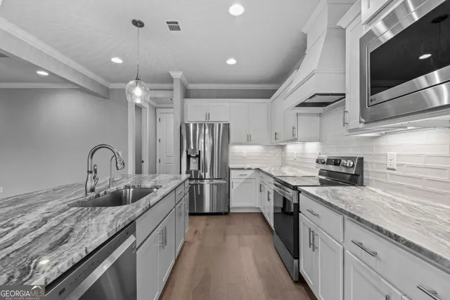 a kitchen with stainless steel appliances granite countertop lots of counter top space and cabinets