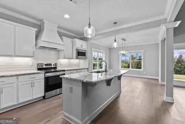 a kitchen with stainless steel appliances granite countertop a sink stove and wooden floor