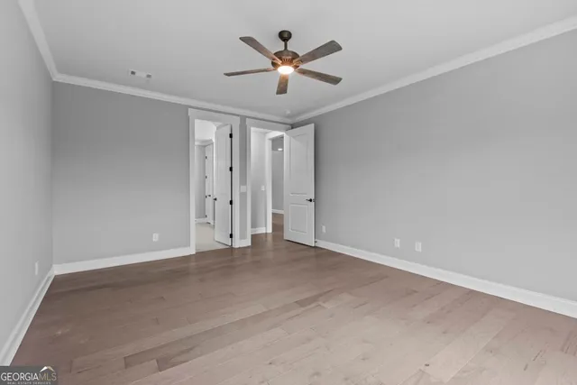 an empty room with closet and ceiling fan