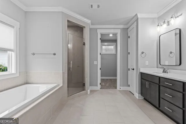 a spacious bathroom with a tub sink shower and mirror