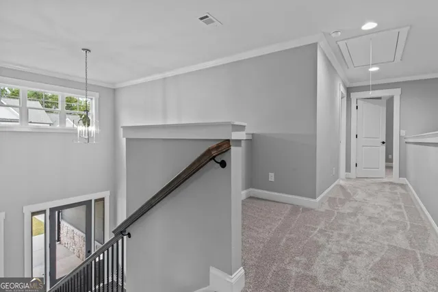 a view of hallway with stairs and chandelier