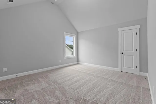a view of an empty room with window and closet area