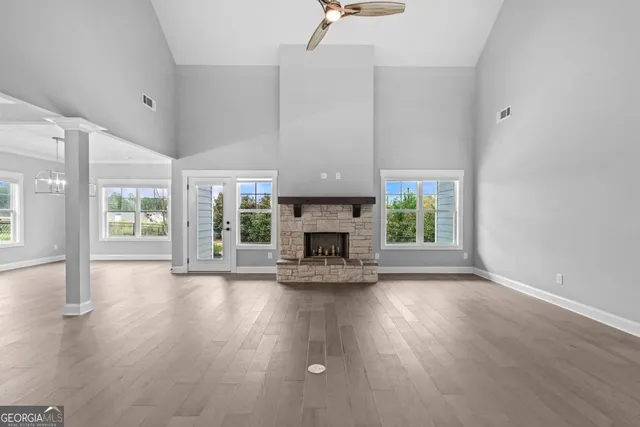 a view of a livingroom with wooden floor a fireplace and window
