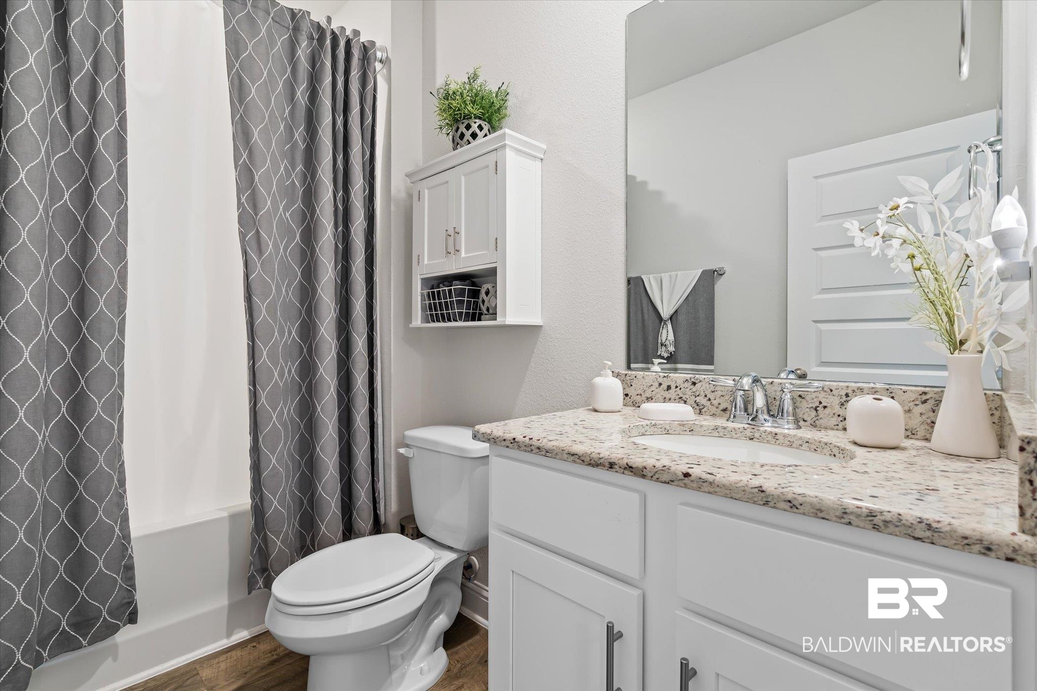 23246 Lieutenant Avenue Foley, AL 36535 - Photo 22 of 36 Full bathroom featuring vanity, hardwood / wood-style flooring, toilet, and shower / bath combo with shower curtain