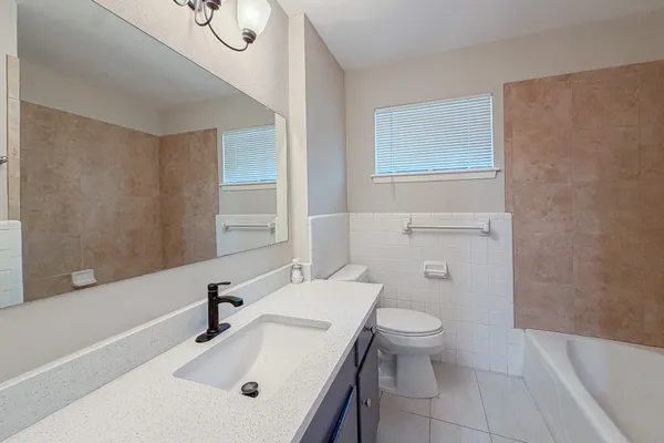 a bathroom with a sink a toilet and a mirror