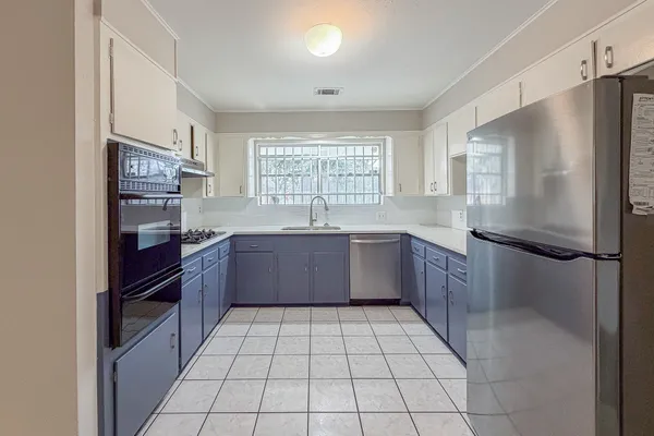 a kitchen with stainless steel appliances a refrigerator sink and cabinets