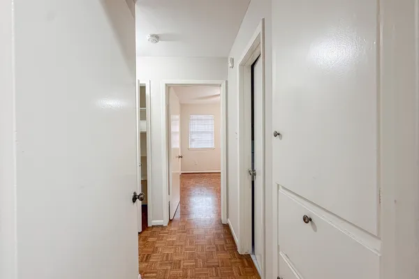 a view of a hallway with wooden floor