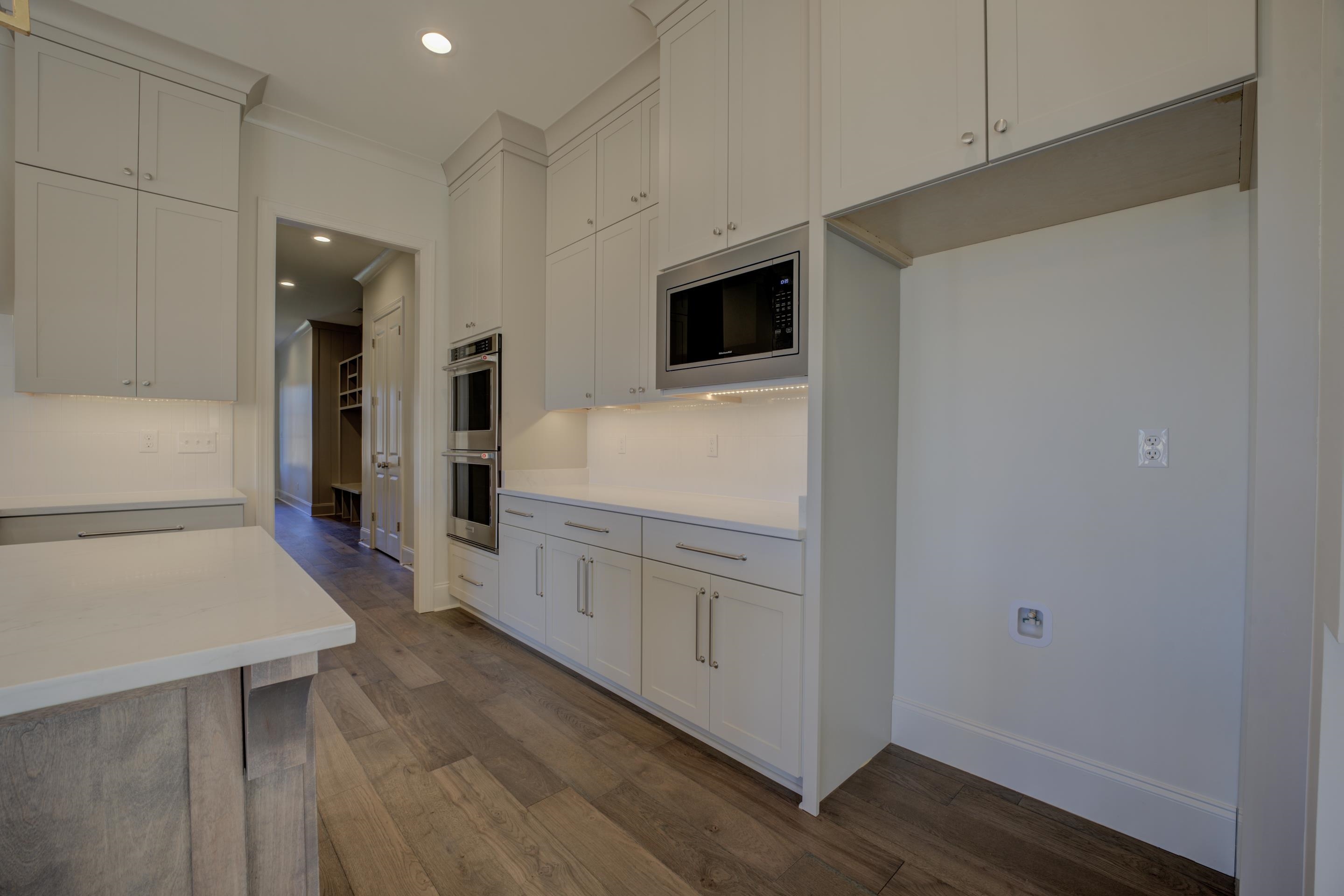 3329 Bailey Station Road Collierville, TN 38017 - Photo 6 of 31 Kitchen with crown molding, dark wood flooring, and stainless steel appliances.