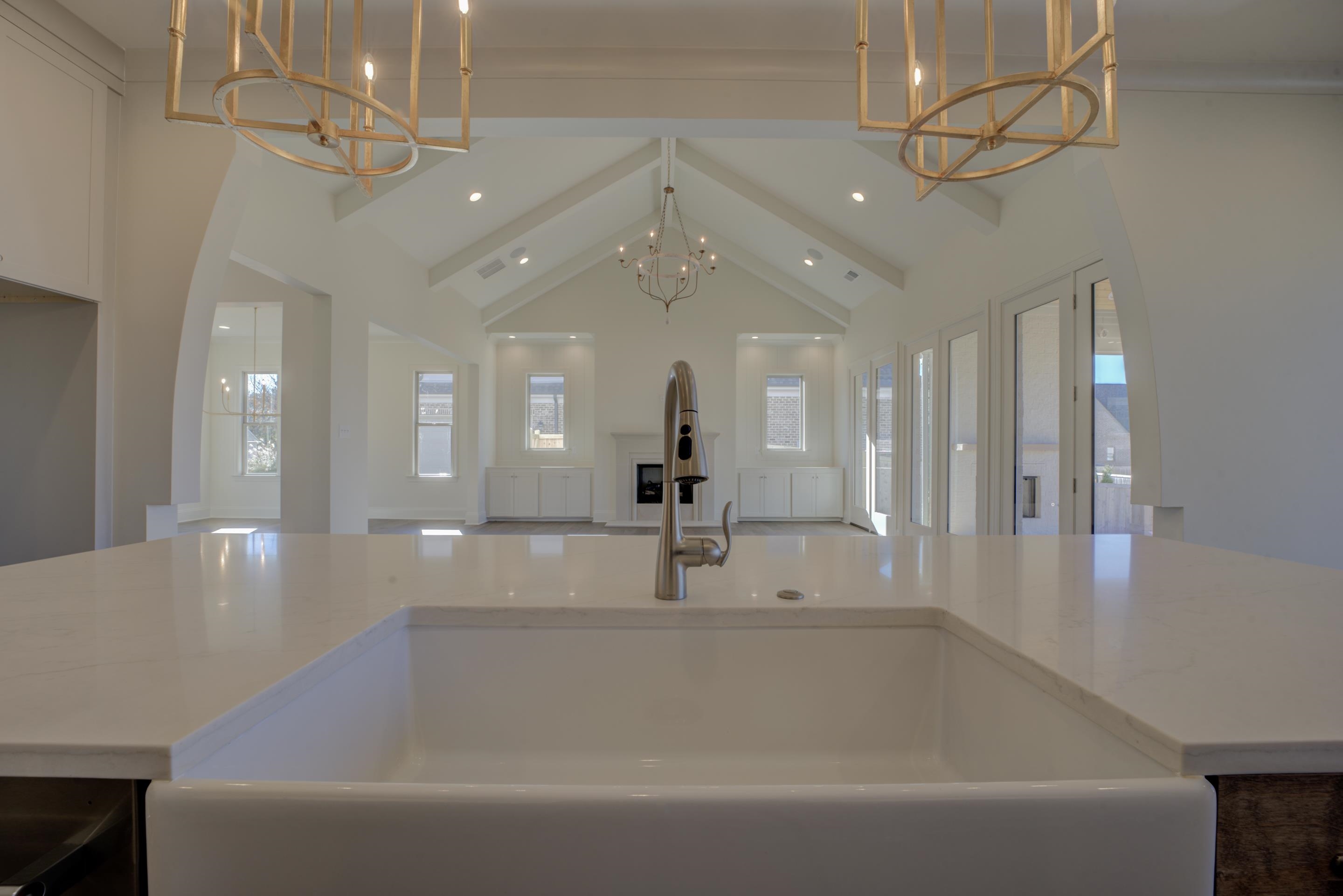 3329 Bailey Station Road Collierville, TN 38017 - Photo 8 of 31 Kitchen with sink, decorative light fixtures, vaulted ceiling with beams, a notable chandelier, and light stone counters