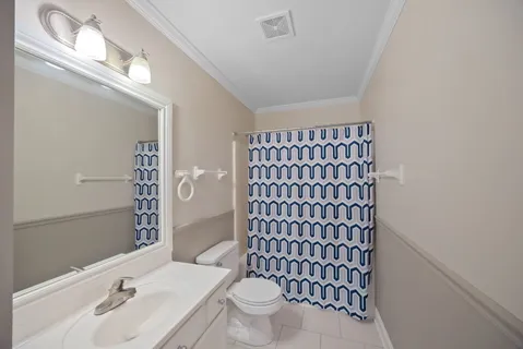 a bathroom with a sink a toilet and shower curtain