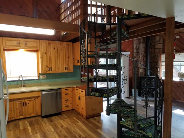 a kitchen with stainless steel appliances granite countertop a sink and wooden cabinets