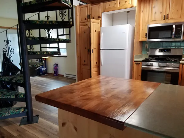a kitchen with granite countertop a refrigerator and a stove top oven
