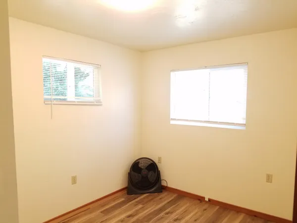 a view of a room that has a window and wooden floor