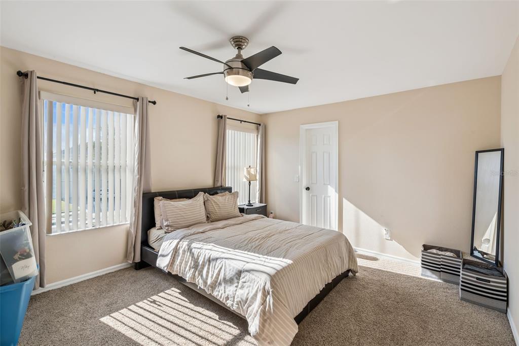 1411 Clarks Summit Court Orlando, FL 32828 - Photo 19 of 50 a bedroom with a large bed and a chandelier