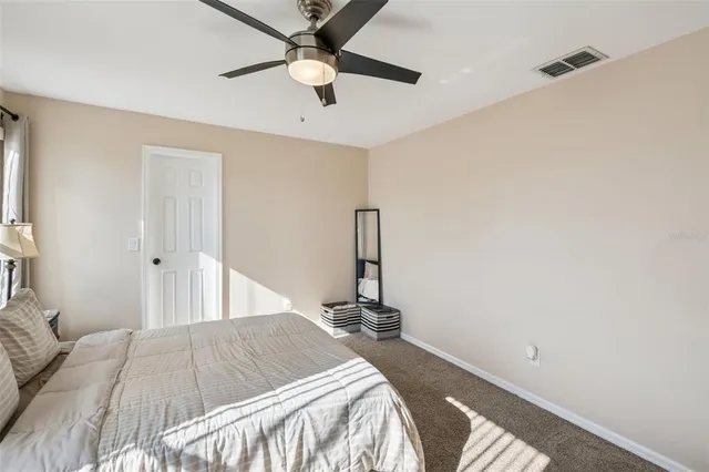 a bedroom with a bed and a ceiling fan