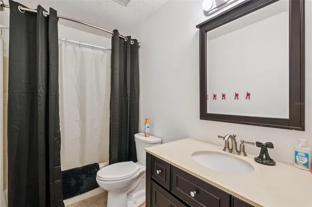 a bathroom with a granite countertop sink toilet and a mirror