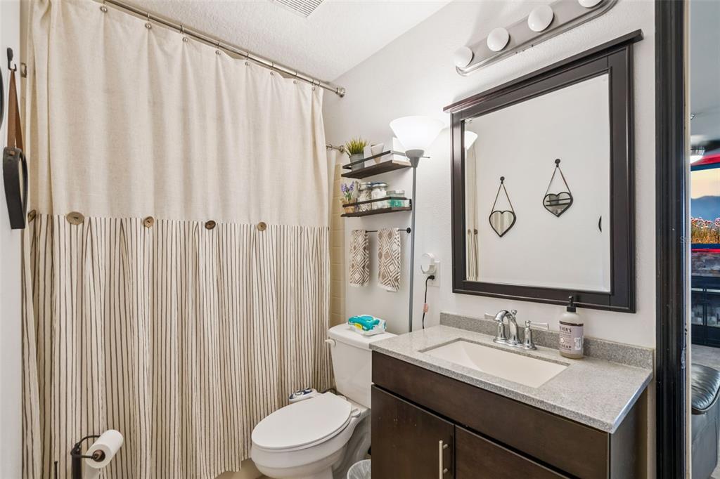 1411 Clarks Summit Court Orlando, FL 32828 - Photo 26 of 50 a bathroom with a granite countertop sink a toilet and a mirror
