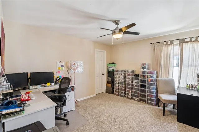 a view of a workspace with furniture and a window
