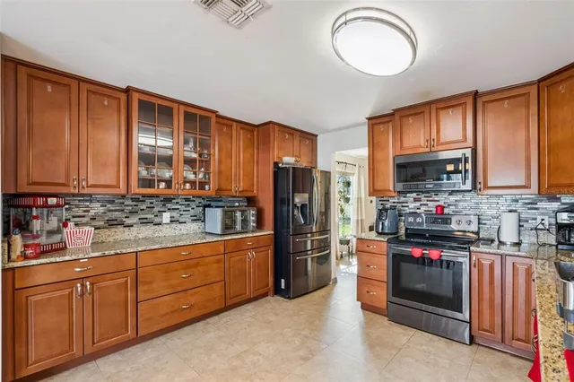 a kitchen with stainless steel appliances granite countertop a stove refrigerator and cabinets