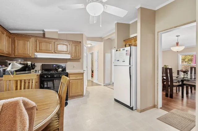 a kitchen with sink a refrigerator and chairs