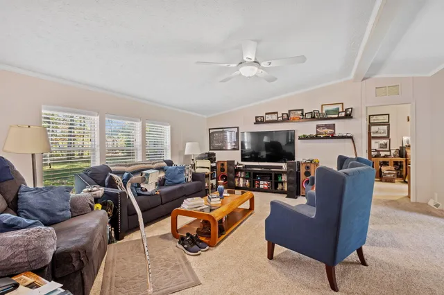 a living room with furniture a flat screen tv and a window