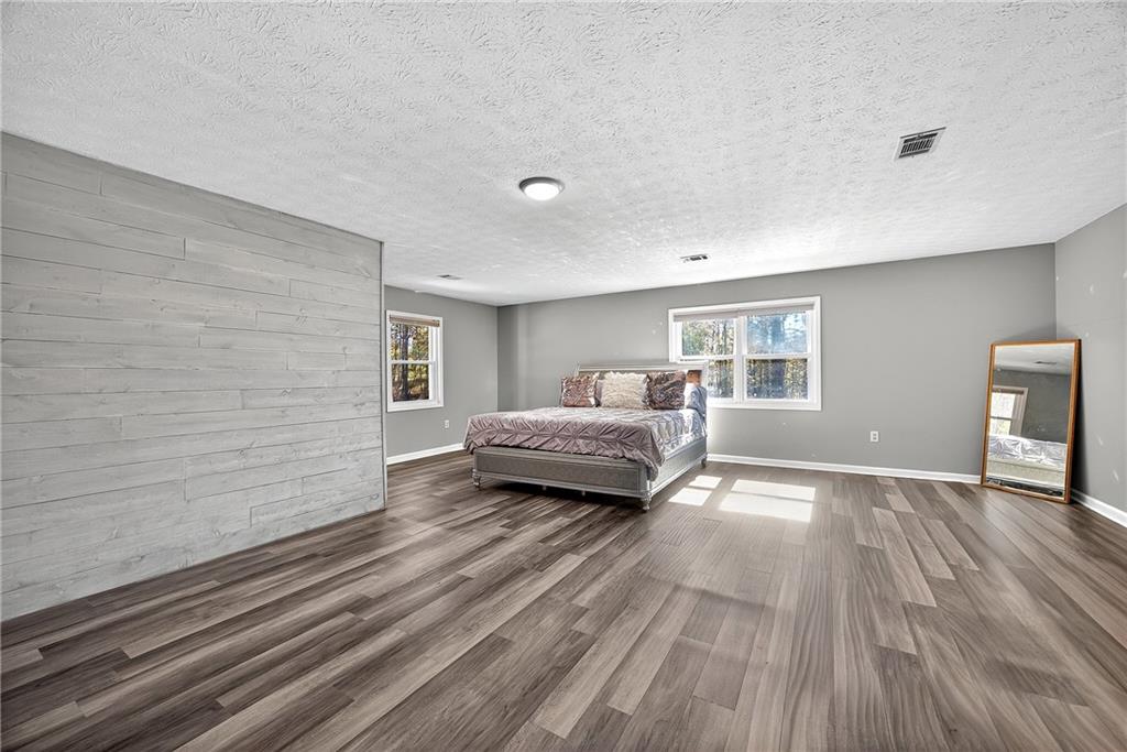 146 Highview Road Southeast Milledgeville, GA 31061 - Photo 15 of 30 a spacious bedroom with a bed and wooden floor