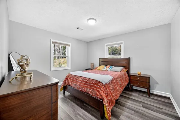 a bedroom with a bed and wooden floor