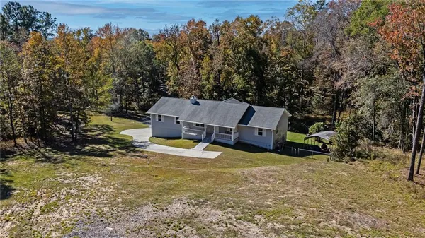 an aerial view of a house with yard and tree s
