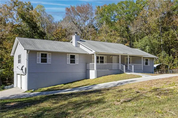 a front view of a house with a yard and trees