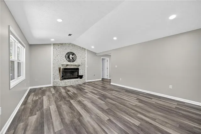 a view of empty room with wooden floor and fireplace