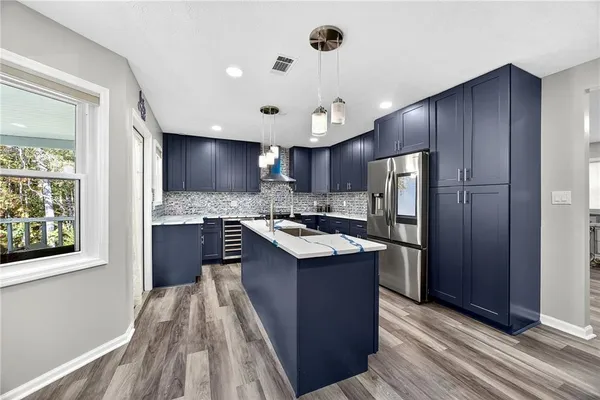 a kitchen with kitchen island granite countertop wooden cabinets a sink and a stove