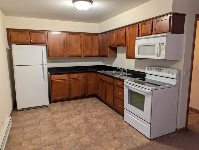 a kitchen with stainless steel appliances granite countertop a stove a refrigerator and a sink