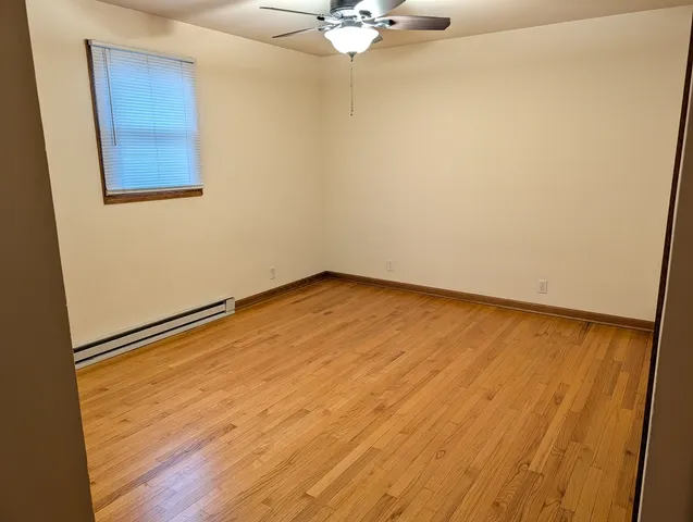 an empty room with a window and a ceiling fan
