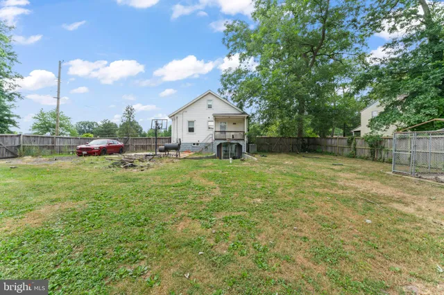 a view of a house with a big yard and large trees