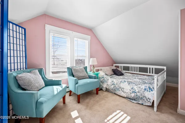 a bedroom with furniture and a large window
