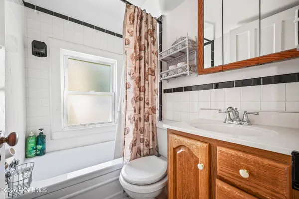 a bathroom with a granite countertop bathtub sink vanity mirror and toilet