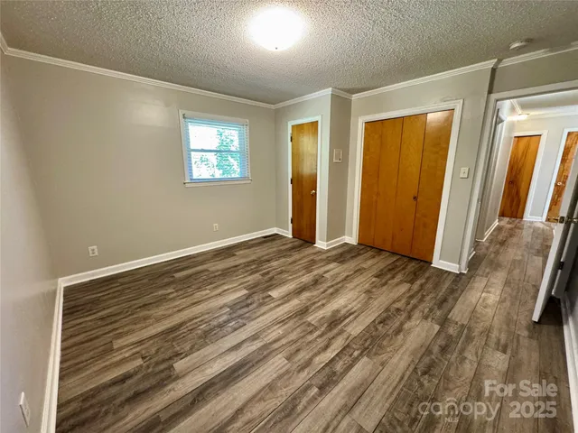 a view of a big room with wooden floor and windows
