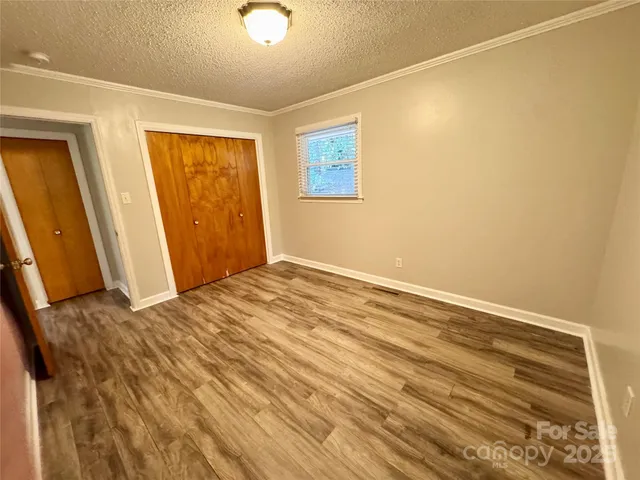 a view of a room with wooden floor and a ceiling fan