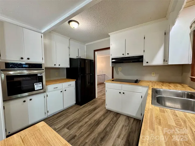 a kitchen with stainless steel appliances white cabinets a sink and a stove