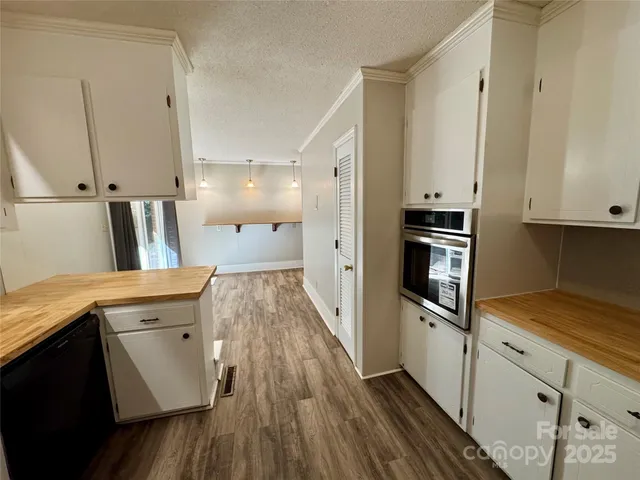 a kitchen with cabinets and wooden floor