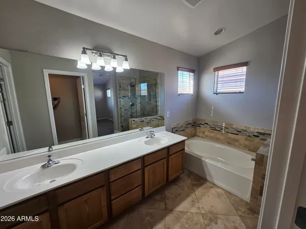 a bathroom with a tub sink and mirror