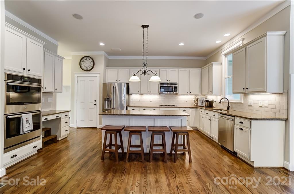 829 Elswick Court Fort Mill, SC 29708 - Photo 19 of 48 a large kitchen with granite countertop lots of counter space dining table and stainless steel appliances
