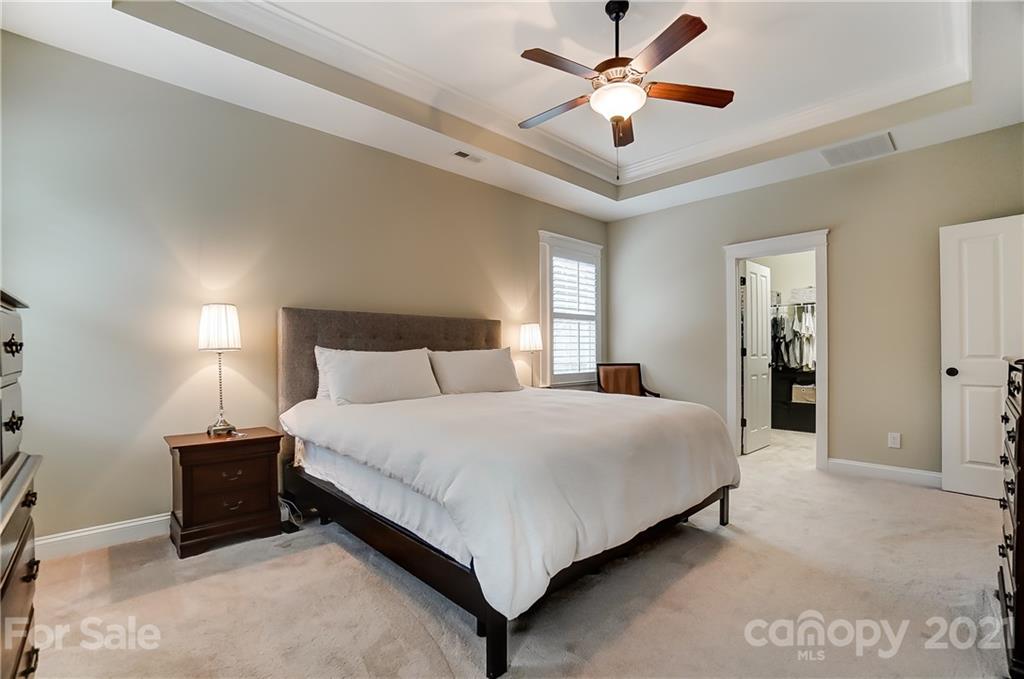 829 Elswick Court Fort Mill, SC 29708 - Photo 29 of 48 a spacious bedroom with a bed and a ceiling fan