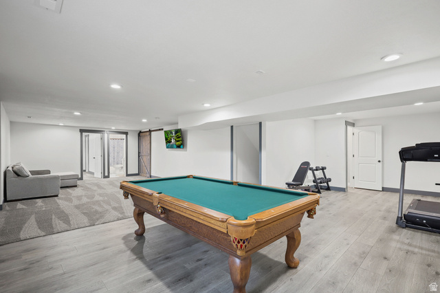 1588 West Rim Rock Drive Stockton, UT 84071 - Photo 27 of 61 Spacious recreation area featuring recessed lighting, a combination of wood-finish flooring and patterned carpeting, and multiple doorways