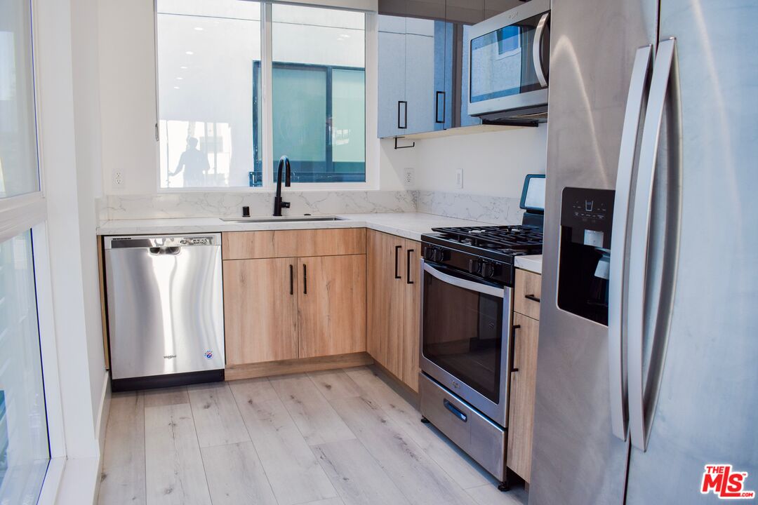 15328 Weddington Street, Unit 1 Sherman Oaks, CA 91411 - Photo 3 of 13 a kitchen with a refrigerator stove and sink